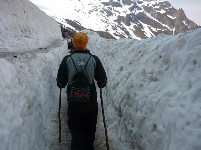 Pilgrims walking through a corridor cut in the Hemkund glacier