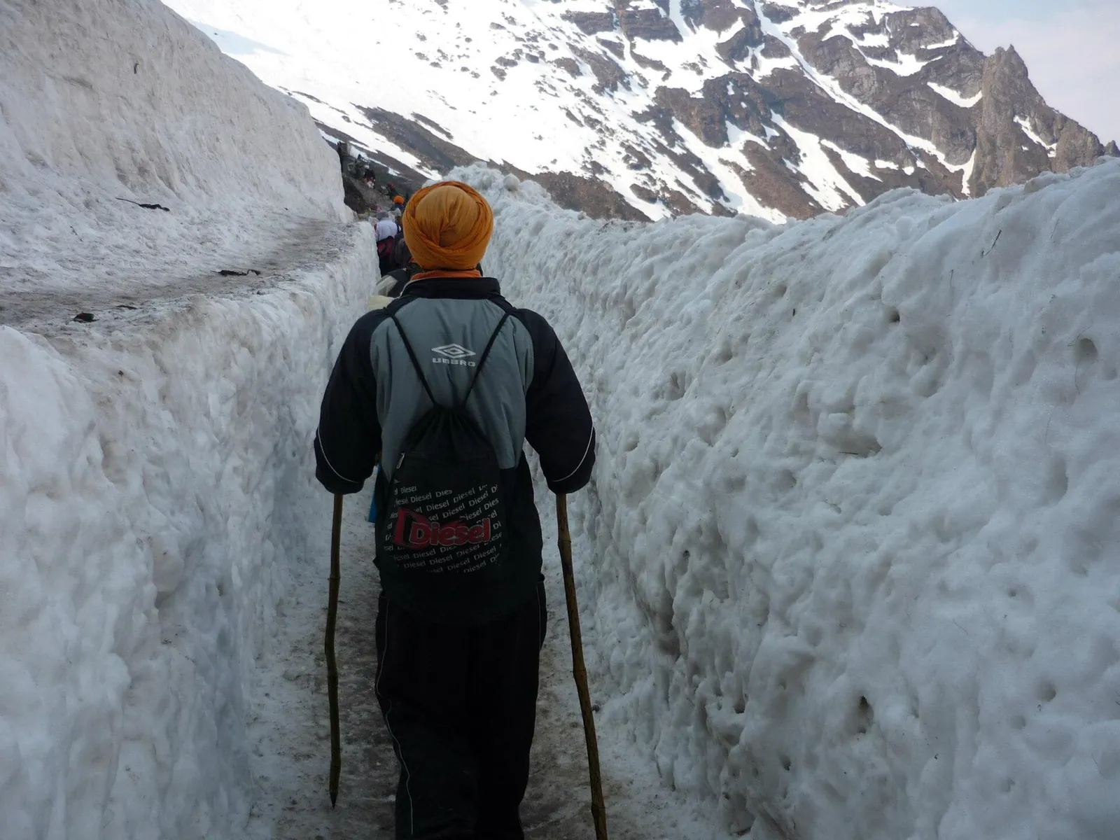 Pilgrims walking through a corridor cut in the Hemkund glacier